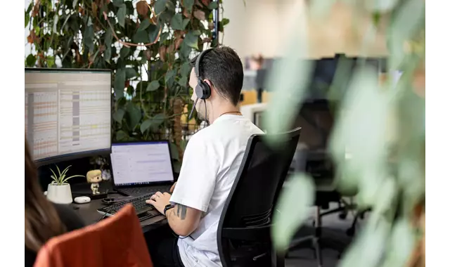 Person working at a desk with greenery surrounding